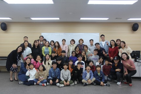 시흥꿈나무 세계속으로! 해외견학체험단 성과발표회에 함께한 참가자와 학부모들이 단체 기념사진을 찍고 있다