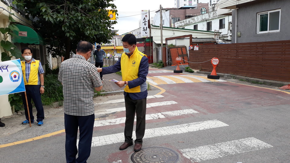 래왕사는 시민을 상대로 범죄예방 전단지를 배포하며 설명하고 있는 모습 [사진=송기문]