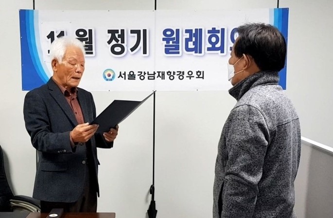 정수헌 회장이 이칠우 이사에게 서울지방경찰청장 표창장을 수여하고 있다.
