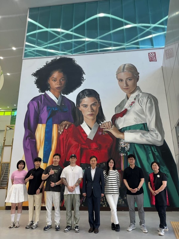 박후근 한국한복원장과 직원들이 그라피로 표현한 벽화 앞에서 기념촬영하는 모습(사진=박후근 원장 페북캡처)