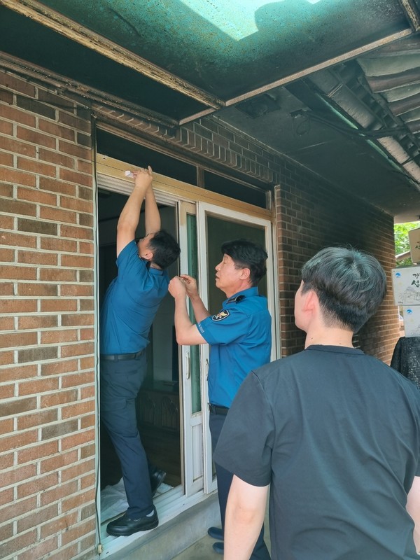인천강화경찰서 경찰관들이 관내 상습 실종 치매어르신 동작감지 센서벨(출입문 차임벨) 설치 작업을 하고 있다.