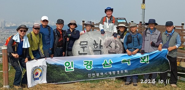 인경산악회가 2024년 10월 중 정기산행에서  '문학산' 정상 표지석 앞에서 기념촬영을 하고 있다.