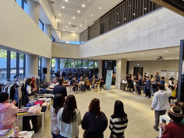 바자회에 섹소폰 연주가 울려 퍼지자 환호하며 박수 갈채를 보내는 참석자들