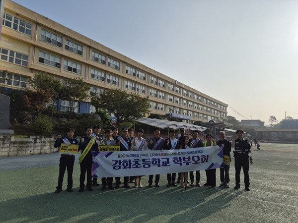 인천강화경찰서가 '안전한 등·하굣길 조성 전기능 합동켐페인'에서 강화초등학교 학부모회와 기념촬영을 하고 있다.